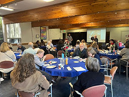 Diverse group of Lutheran Church Members gathered around tables for community event in Kenmore Washington
