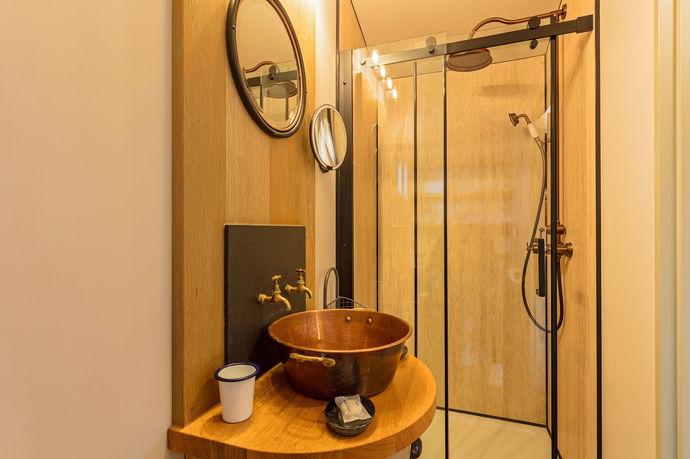 shower and sink within bathroom of shepherds hut accommodation