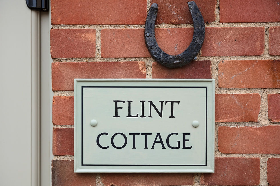 flint cottage sign on brick wall