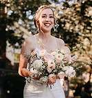 Smiling bride walking down the aisle with romantic blush and peach bouquet, full wedding planning and florals by Wistoria Ev
