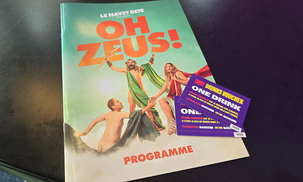 Colorful Oh Zeus! programme on a table, with costumed performers on the cover and purple drink vouchers overlapping the corner.