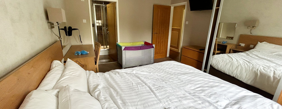 Master bedroom in the Diamond Cottage featuring a double bed, mirrored wardrobe, en-suite bathroom, TV, and travel cot.