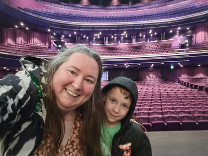 Lowry Backstage Tour - Smiling woman and young boy take a selfie in a purple-seated theater with balcony lights.