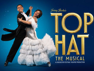 Dancing couple in elegant attire, man in a tuxedo, woman in a flowing white dress, against blue backdrop. Text: "Irving Berlin's Top Hat The Musical."