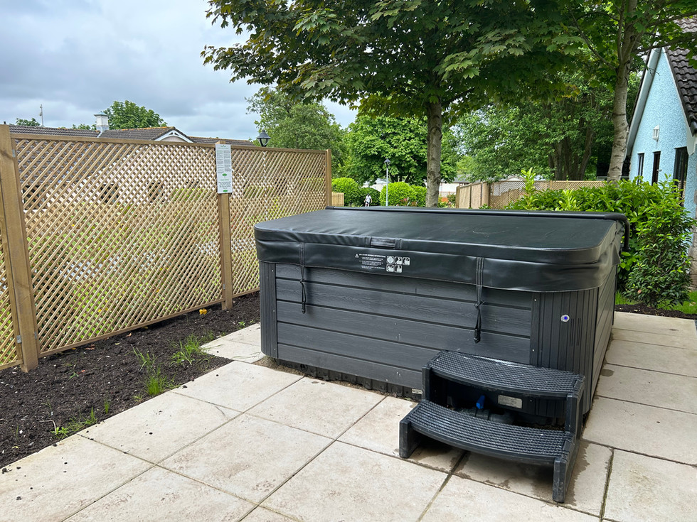 Private outdoor hot tub area at the Diamond Cottage with patio space and fenced surroundings at Ribby Hall Village.