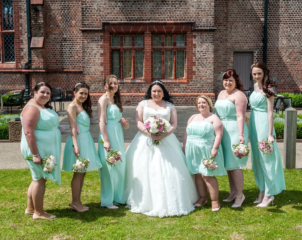 Sarah with her six bridesmaids in mint green dresses at Ordsall Hall on her wedding day.