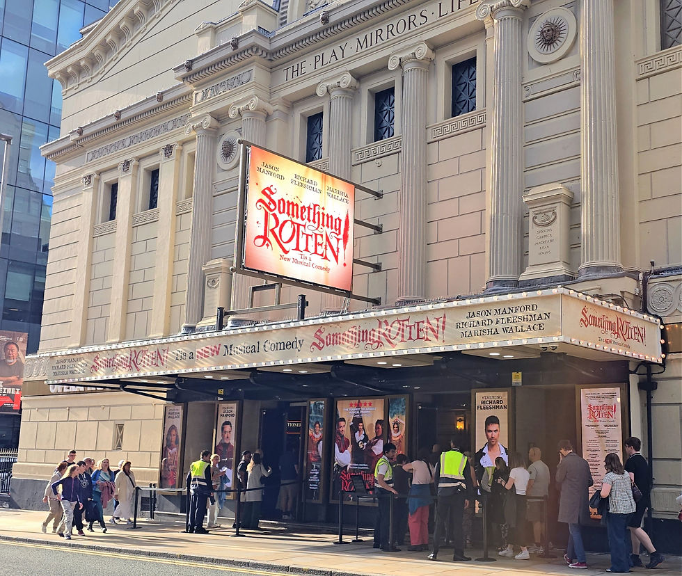 Theater facade with Something Rotten! marquee; crowds line up outside under columns and posters for the Broadway musical.