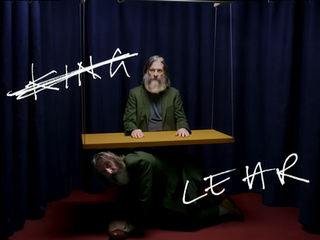Official artwork for King Lear at the Royal Exchange Theatre, featuring David Threlfall in a green suit against dark curtains with the production title in white lettering.