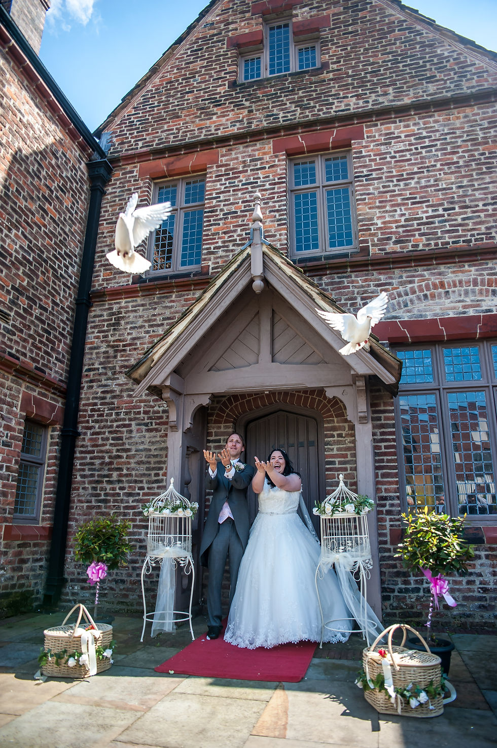 Sarah and Lawrence successfully releasing two white doves after their wedding ceremony at Ordsall Hall.