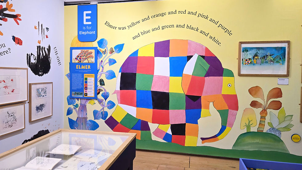 Wild things exhibition at the lowry - Colourful patchwork elephant mural in a museum exhibit, labeled E is for Elephant, with Elmer text on the wall.