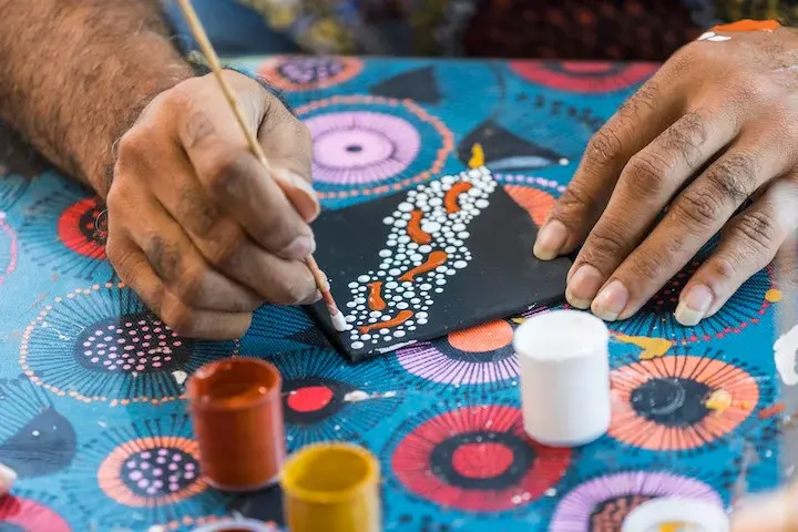 traditional aboriginal artist producing piece.