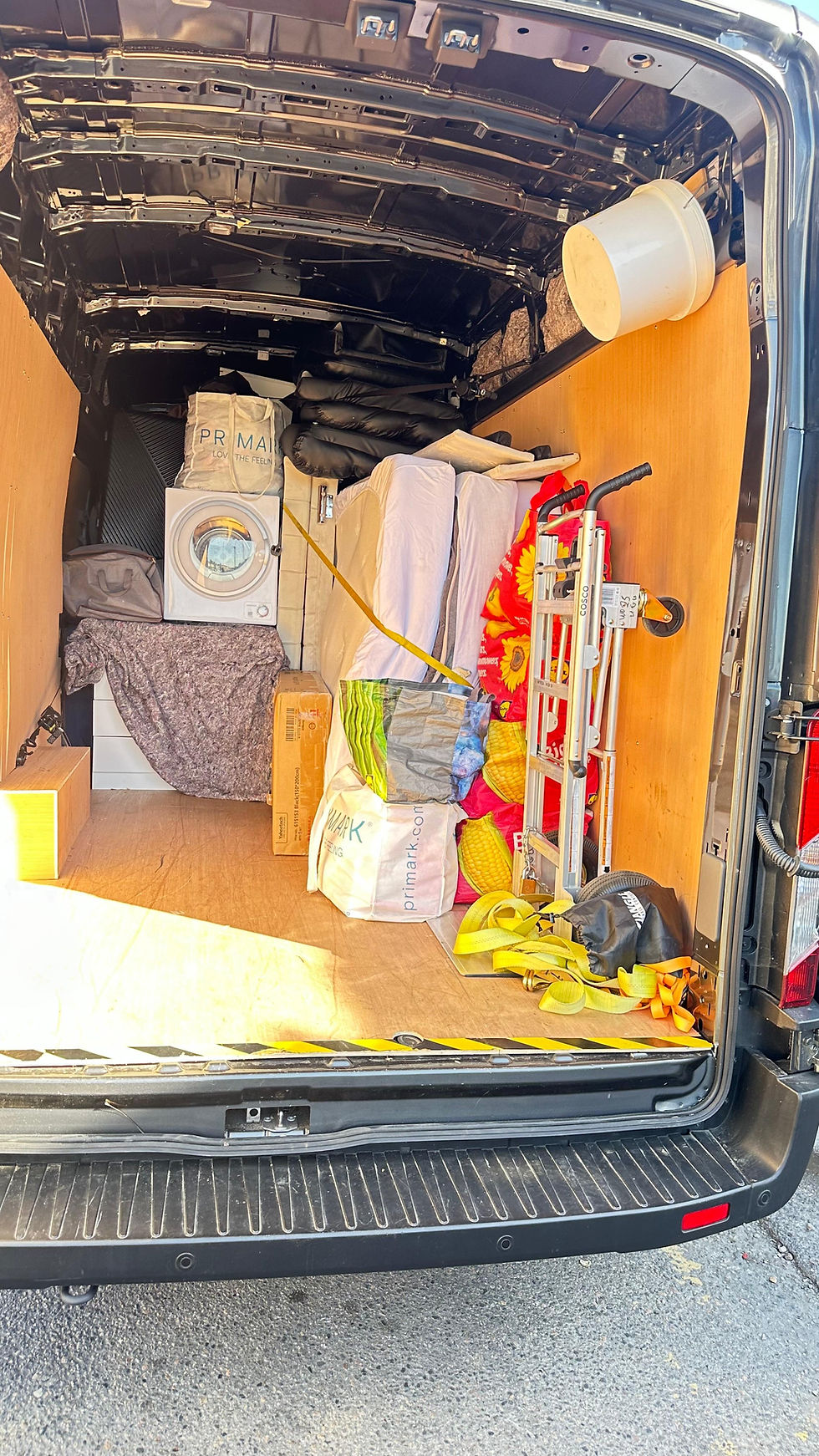 Back of removal london van filled with bags, boxes, fridge