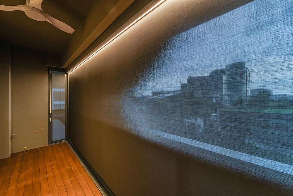 ZipBlind outdoor blinds installed along a balcony, creating a shaded and private outdoor space with soft ambient lighting.