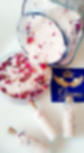 Rose petals and salt spilling from jar with "Grames" text, white background.