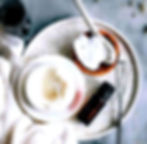 Overhead view, ingredients, wooden bowl, essential oil, and whisk. White cream preparation, natural skincare.