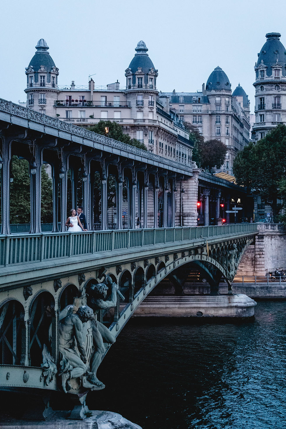 Brautpaar auf der Pont de Bir-Hakeim in Paris, umgeben von eleganten Sรคulen, mit Blick auf den Eiffelturm Hochzeitsfotografie