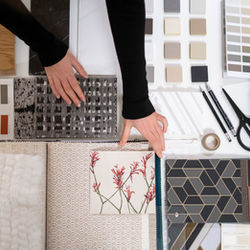 picture of a womans hands arranging interior design materials and finish samples
