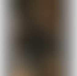 dark moody image of a red wine bottle and glass with wine in it