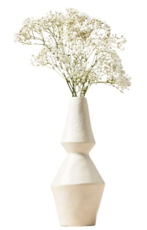 White ceramic vase with geometric design, holding delicate baby's breath flowers. The background is plain white, highlighting the vase's elegance.