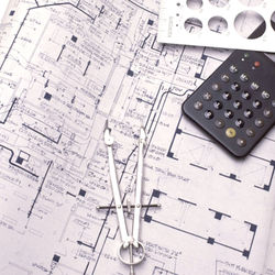 black and white image of construction drawings, floor plan with a calculator