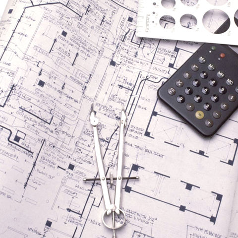black and white image of construction drawings, floor plan with a calculator