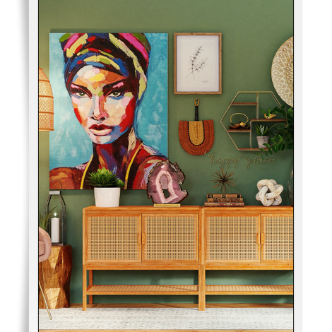 boho interior space with a rattan console and pendants with a green painted wall and bohemian art