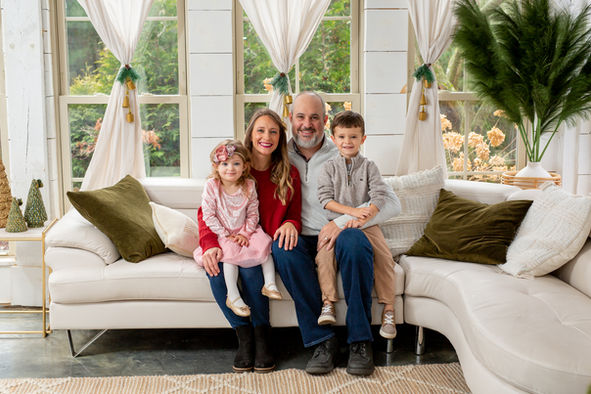 professional family picture studio in Westerville poses family on holiday set for Christmas card