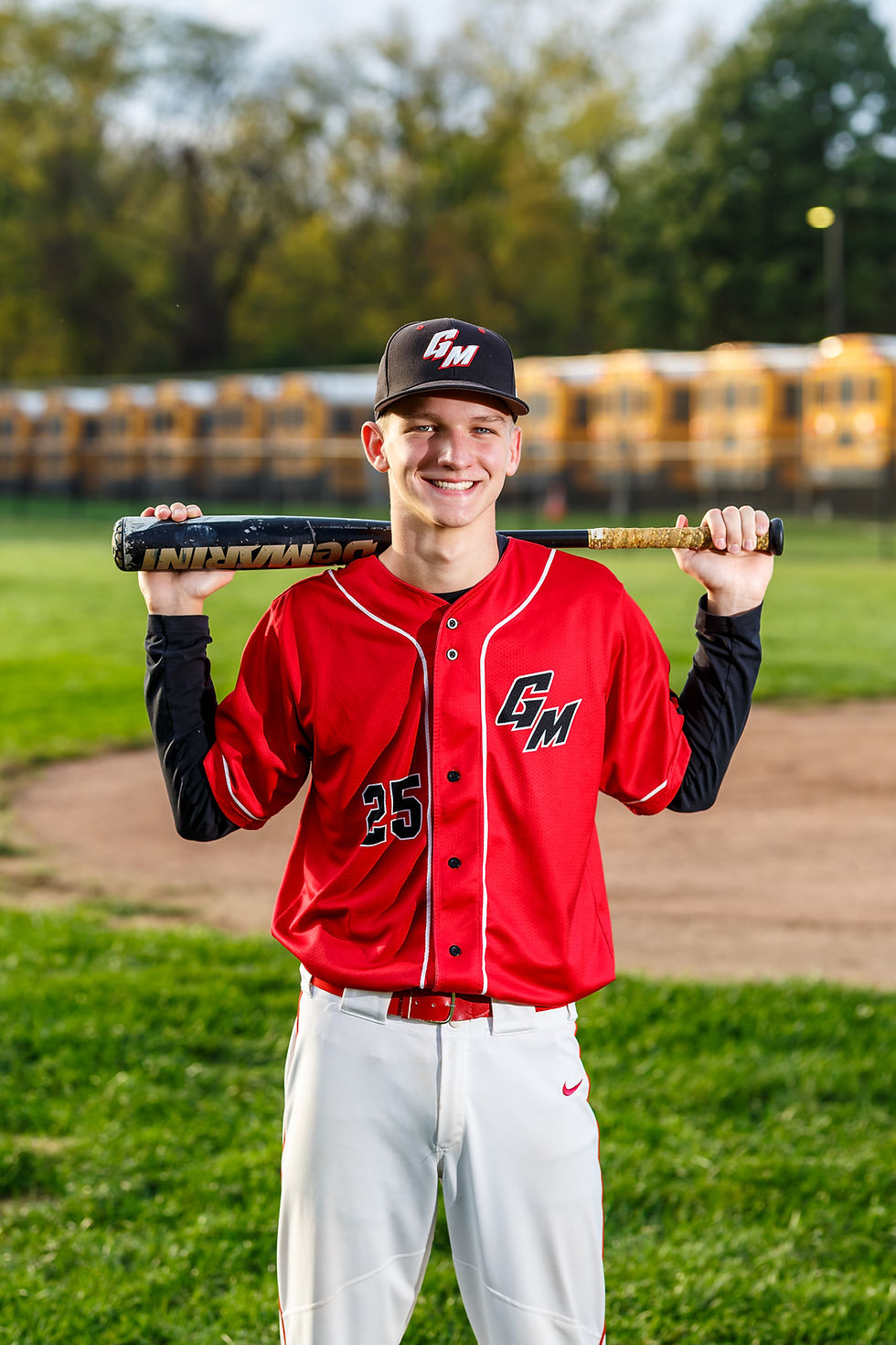 Senior pictures near Westerville and Olentangy baseball in uniform holding bat