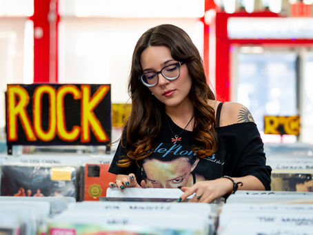 Senior pictures with vinyl and girl looking through records in record store in Columbus Ohio