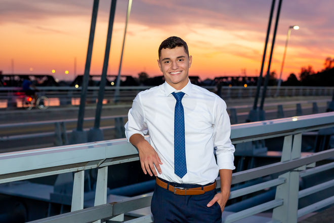 Upper Arlington senior poses for unique senior pictures in downtown Columbus with sunset in the background 