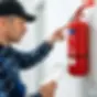 Technician inspects fire extinguisher, HSE Property Compliance