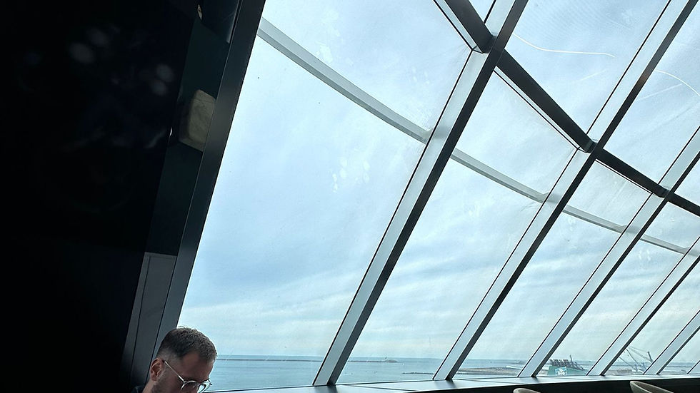 a man sat by a large window