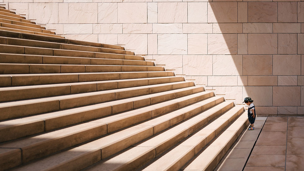 A Kid Looking At the Foot of A Staircase
