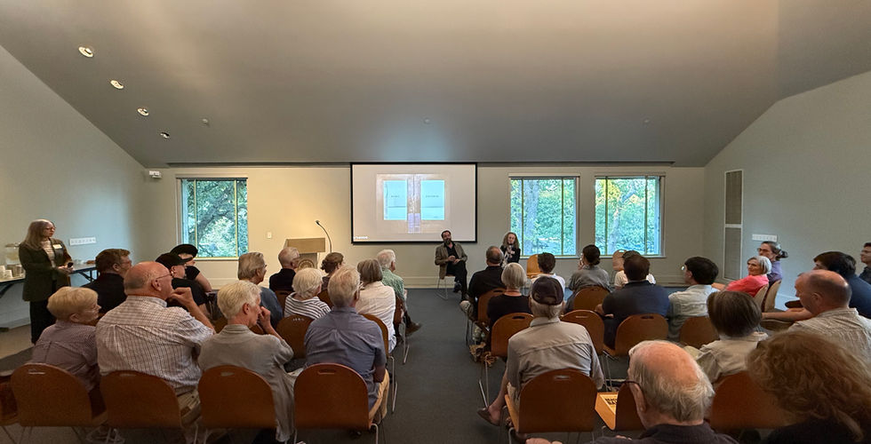 A crowd of people sit and watch Jeremiah Ariaz talk in side the Beach Museum of Art