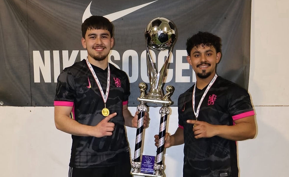 Two intramural soccer players pose with a intramural soccer trophy