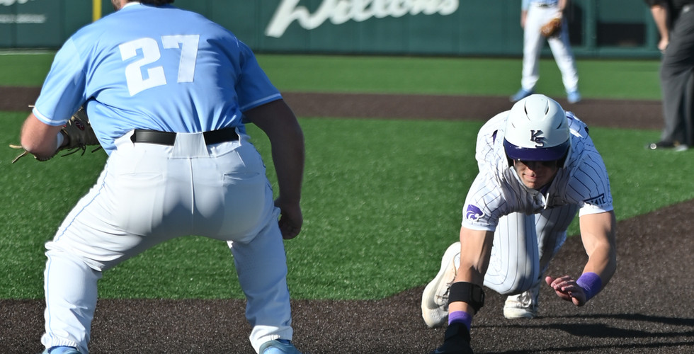 A K-State baseball player slides into first base.