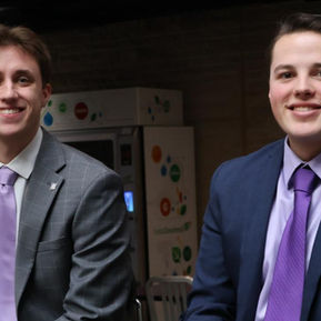 Christian Peña and Caden Bastian sit on stage next to each other.