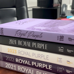 A stack of Royal Purple Yearbooks.
