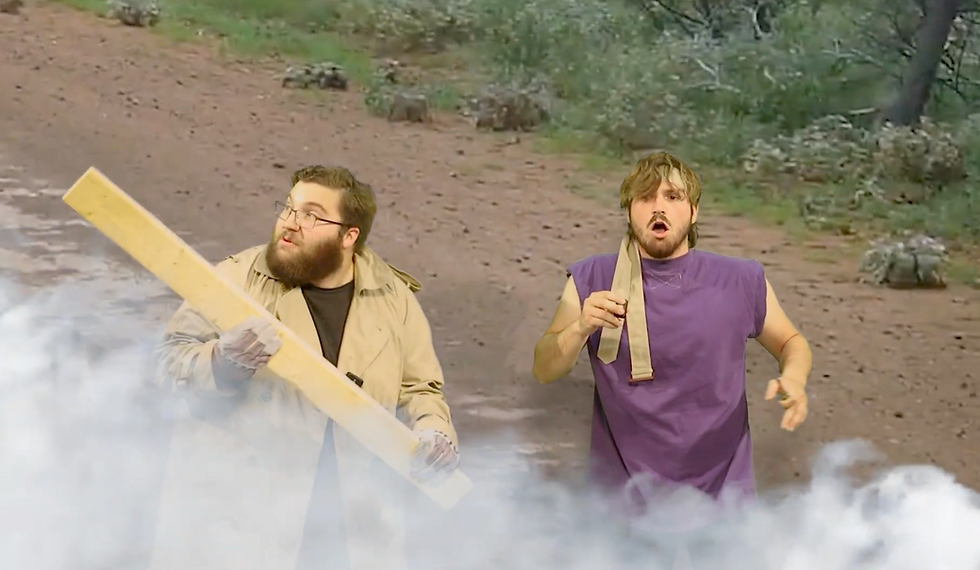 Peter dressed in a long tan jacket and Peter has a purple shirt with a tie around his forehead.