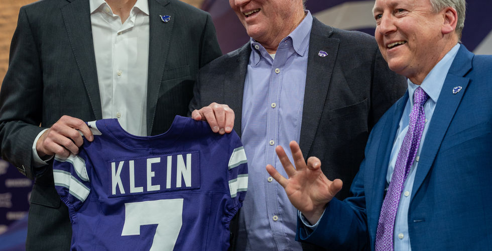 Collin Klein holds a number 7 jersey and poses with Gene Taylor and Richard Linton. 