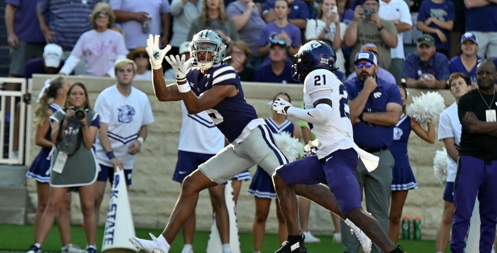 A K-State football player reaches out to catch the ball in the end zone. Courtesy: Zoe Taylor