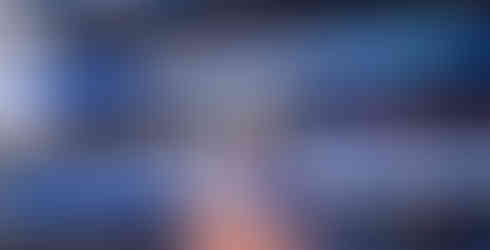 A K-State football player grabs the collar of his pads and stares towards the crowd.