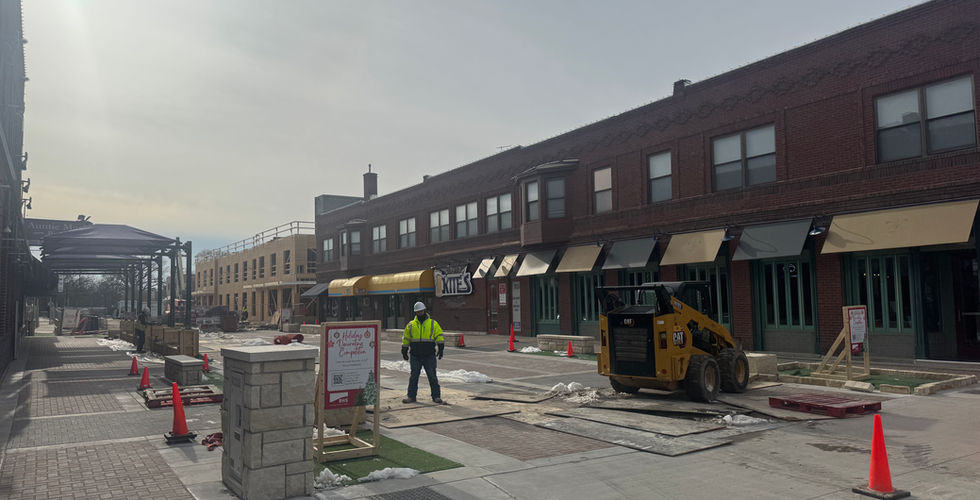 12th street under construction with equipment and worker walking on the street.