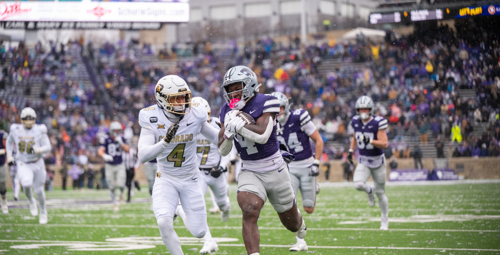 Joe Jackson runs the ball down the field while it snows.