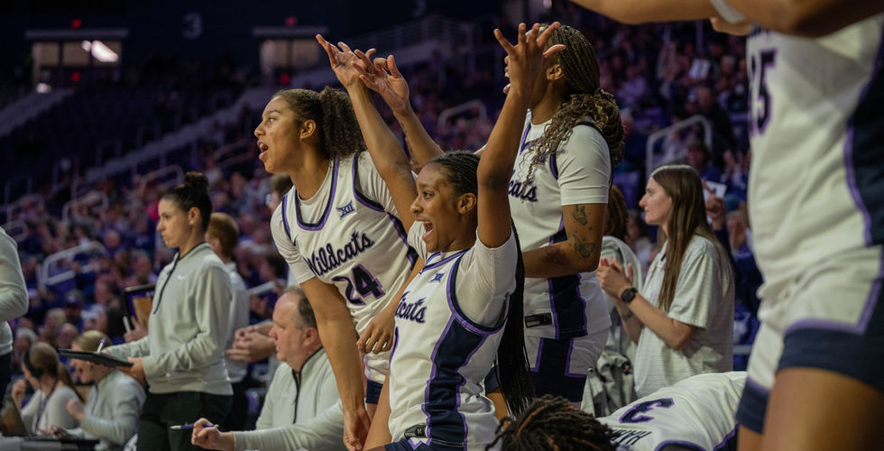 K-State women basketball team member celebrate on the sideline.