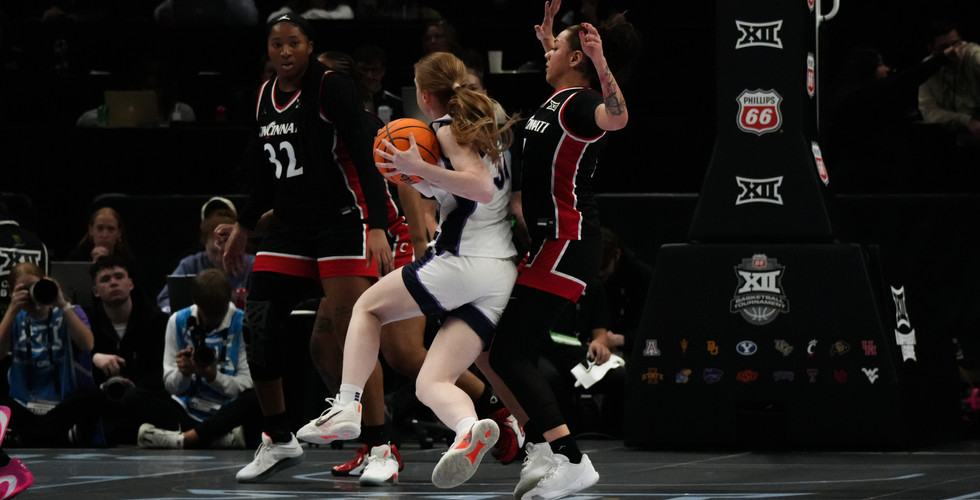 A K-State women's basketball player drives towards the goal.