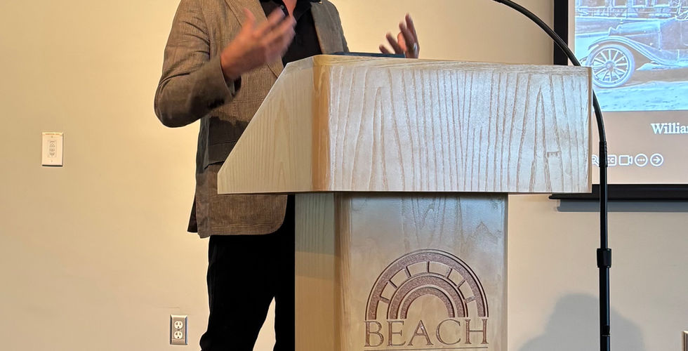 Jeremiah Ariaz standing and talking in front of the podium at the Beach Museum of Art