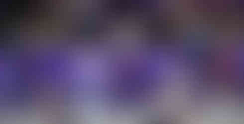 The K-State volleyball team huddles at midcourt during the match.