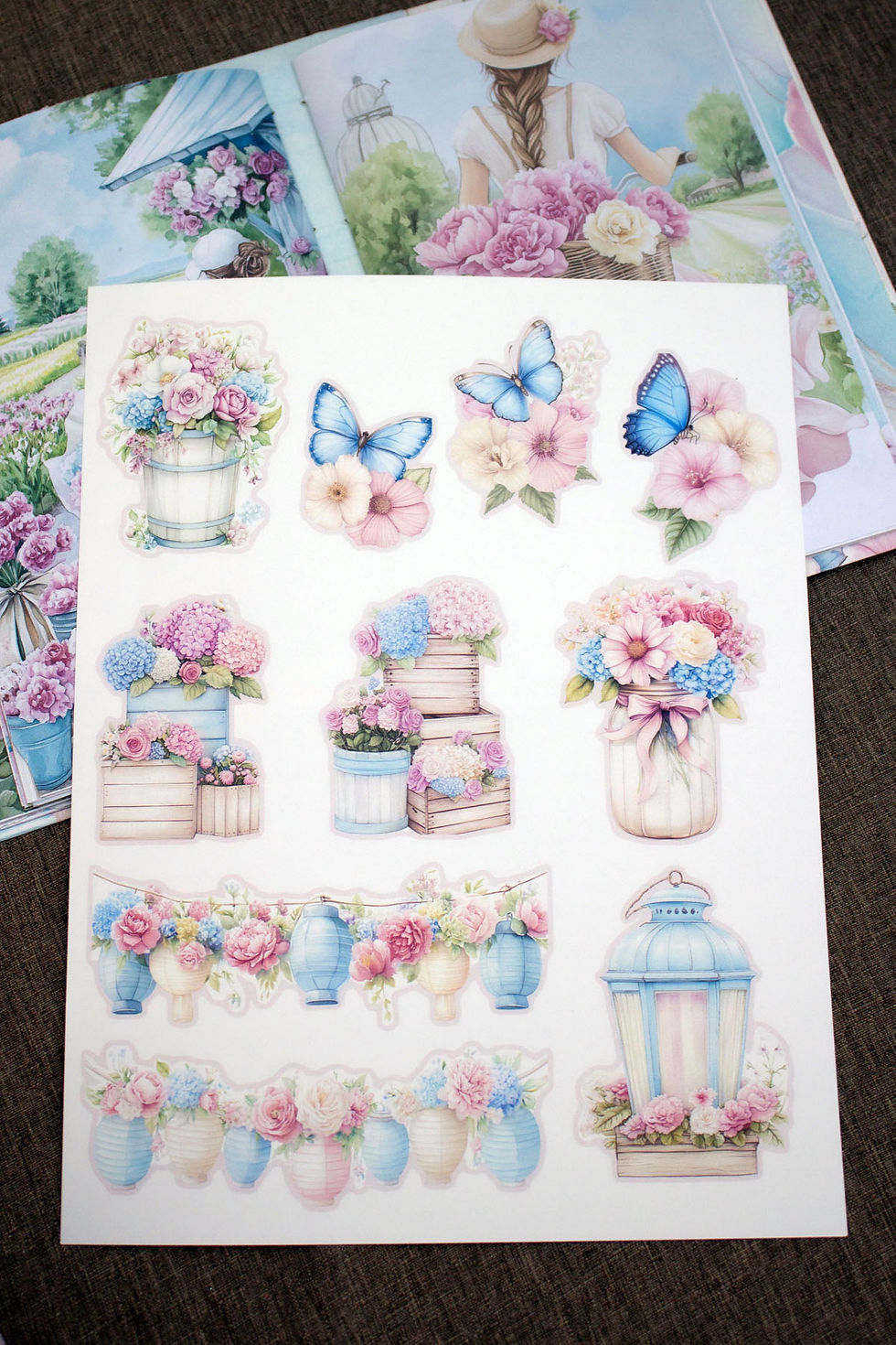 A sheet of floral fussy cuts from the Pink and Blue Flower Farm kit resting on an open junk journal page.