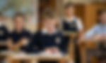 Students at desks in a classroom reading aloud